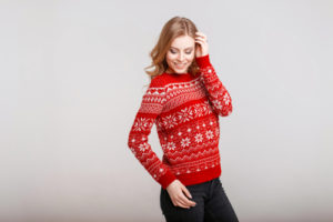 Image of woman wearing a red holiday sweater.