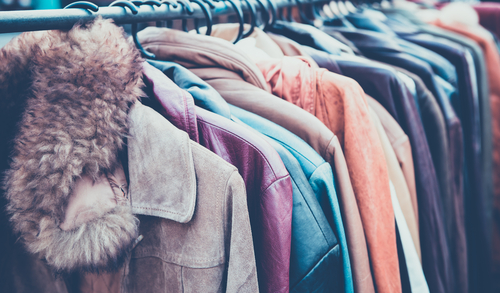Image of winter coats hanging on a clothes rack.

